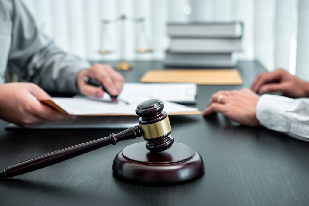 Male lawyer discussing negotiation legal case with client meeting with document contact in courtroom